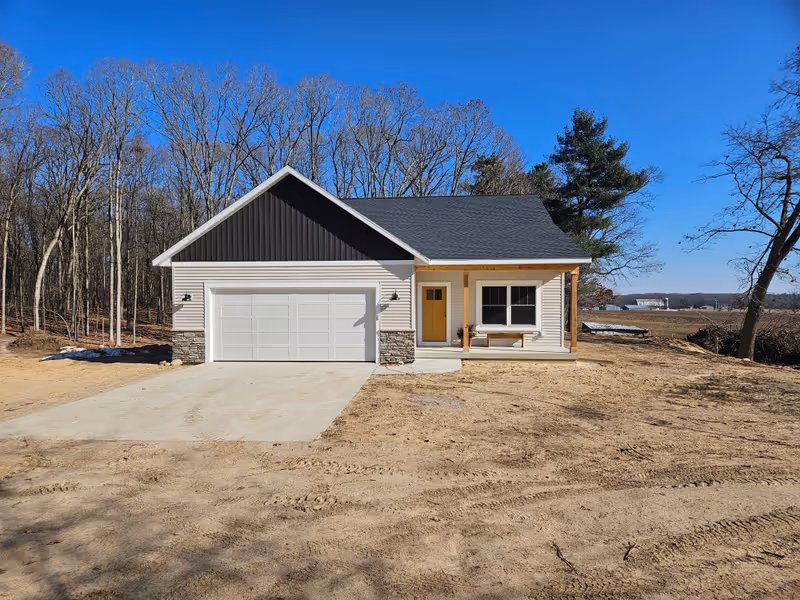 Custom home exterior featuring ranch-style design with dark gray board-and-batten siding