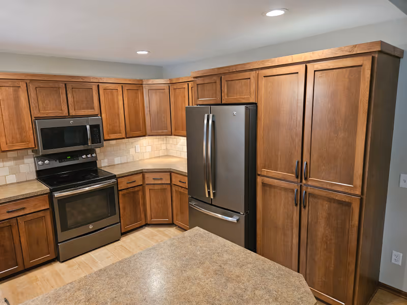 Warm stained kitchen cabinets with full kitchen island in a rich brown tone